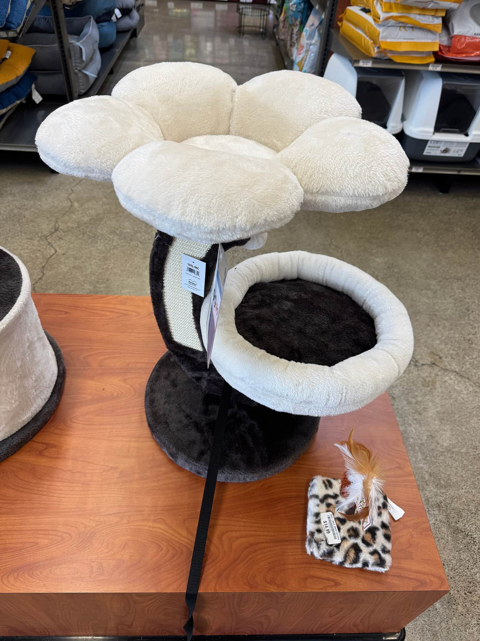 A tall multi-level carpeted cat tower standing in a room